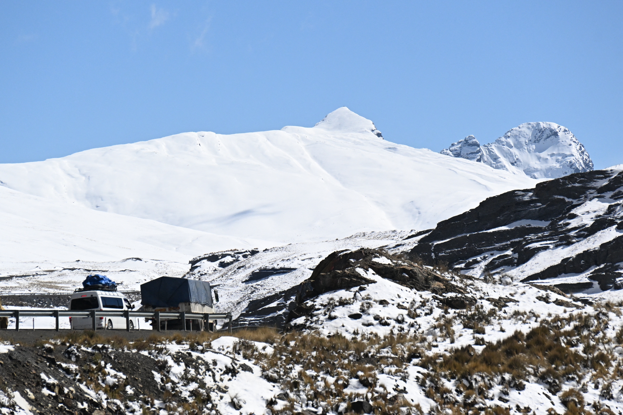 2026年8月25日,玻利維亞拉巴斯省,拉巴斯北部峰區沿永加斯路(Yungas Road)一帶出現異常強降雪,少數車輛沿著盤山路行駛。(Aizar Raldes/AFP via Getty Images)