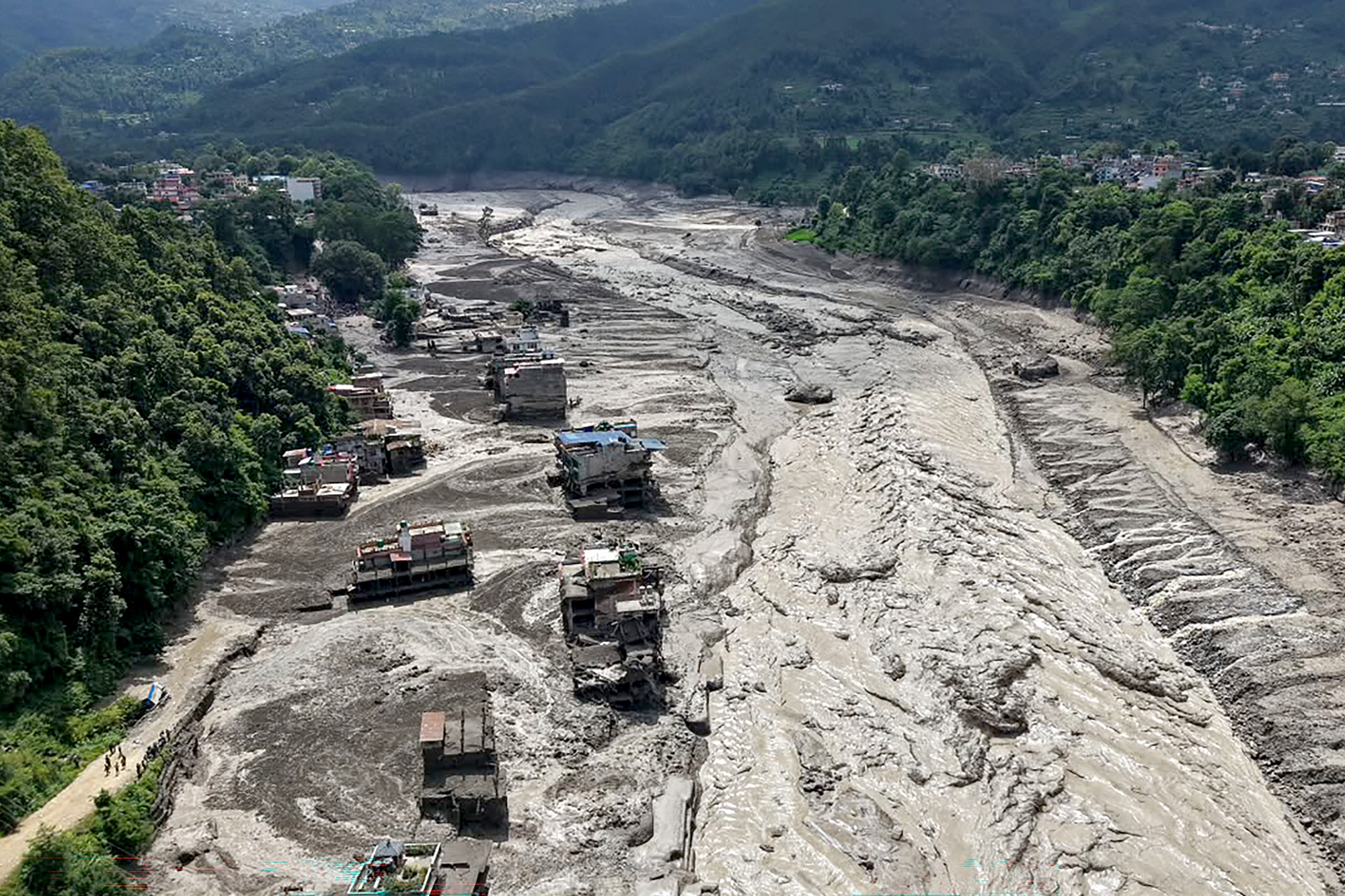 2026年8月26日,尼泊爾努瓦科特縣(Nuwakot)特里蘇里巴扎爾(Trishuli Bazar)發生山洪,河岸邊房屋部分被泥水掩埋。(Prabin Ranabhat/AFP via Getty Images)