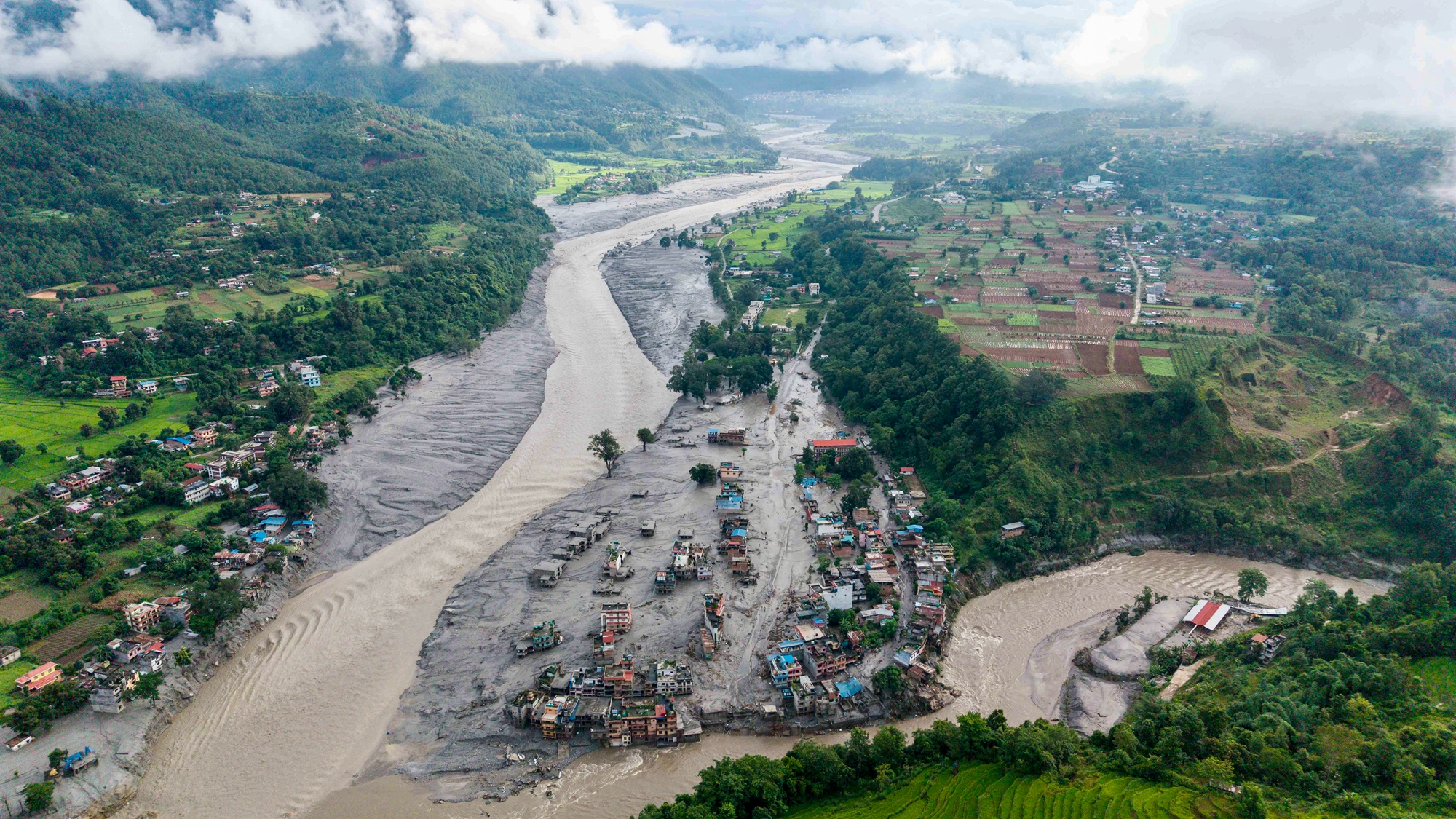2026年8月27日,在尼泊爾特里蘇里河(Trishuli River)和塔迪河(Tadi River)交匯處,努瓦科特縣(Nuwakot)德夫加特(Devghat)的許多房屋被淤泥掩埋。此前一天,中國西藏與尼泊爾交界地區突發大規模泥石流及山洪。(Prabin Ranabhat/AFP via Getty Images)