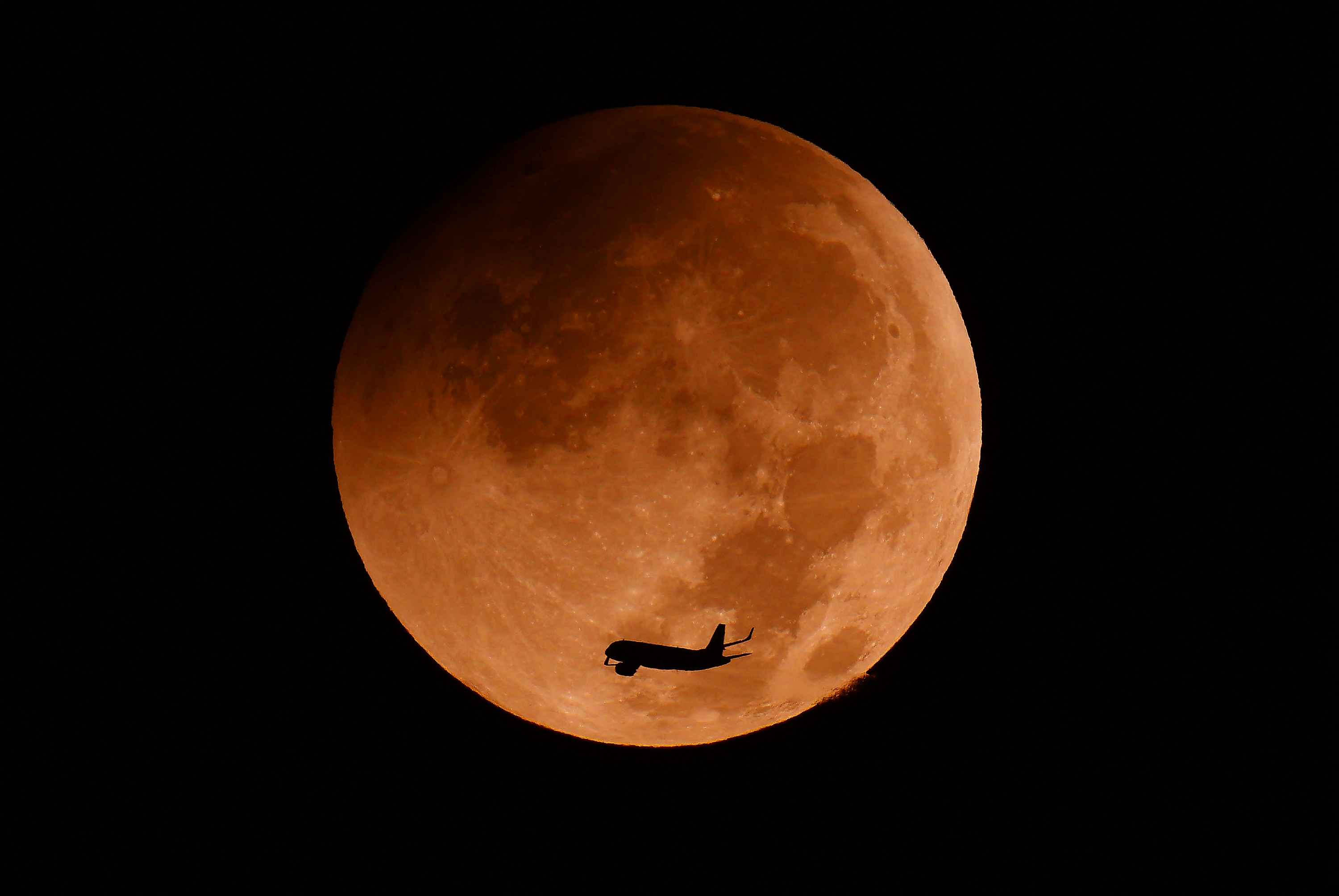 2026年8月28日,一架飛機從以色列沿海城市內坦亞(Netanya)上空的月偏食前飛過。(JACK GUEZ/AFP via Getty Images)