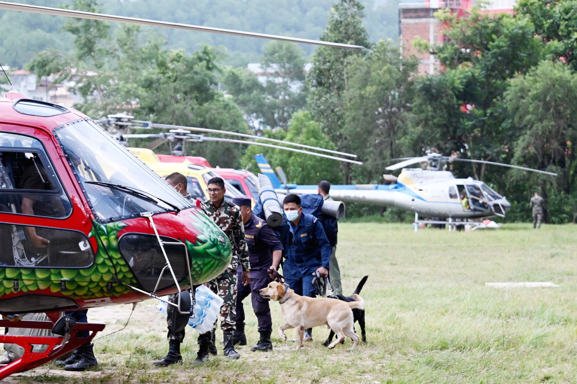2026年8月29日，尼泊尔保安人员携带搜救犬和物资在努瓦科特县的特里苏里军营（Trishuli camp）登上直升机，准备前往灾区救援。(Arun Sankar/AFP via Getty Images)