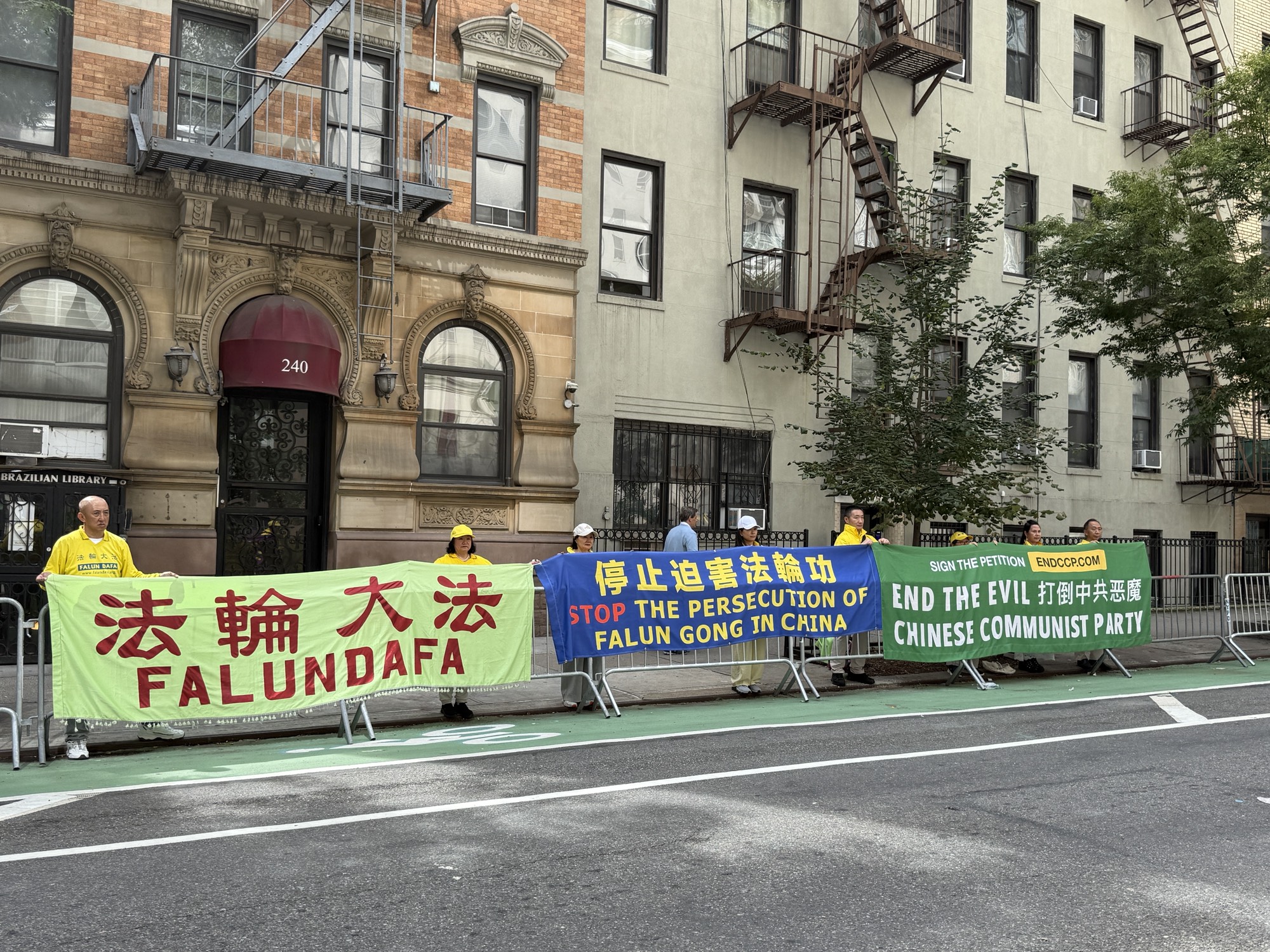 9月22日下午近4點,法輪功學員在聯合國總部附近展示「法輪大法好」「打倒中共惡魔」等中英文橫額,美國總統特朗普及其車隊成員經過時看到。(林丹/大紀元)