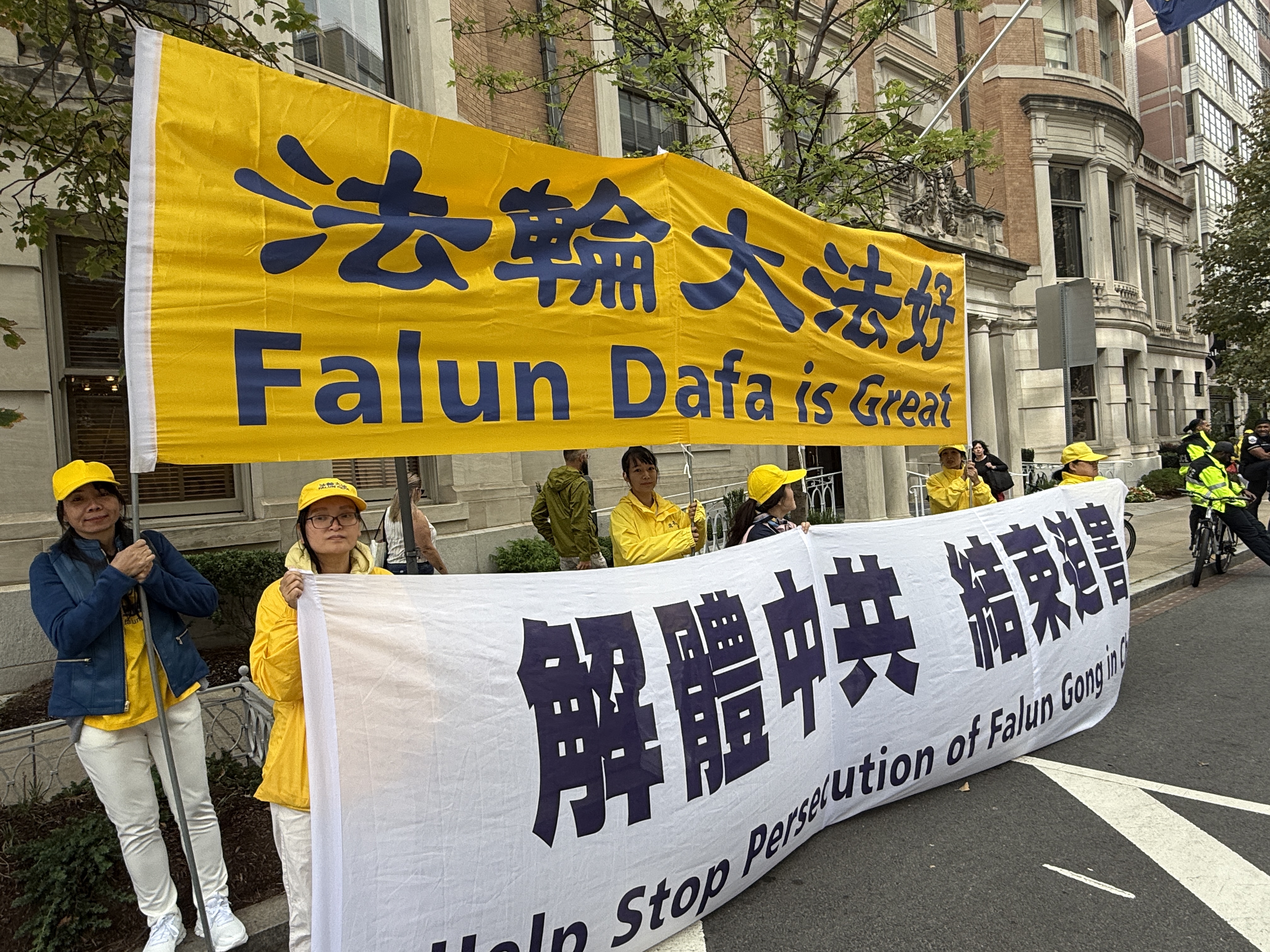 法輪功學員在白宮附近的馬路上打出橫額「法輪大法好」「解體中共,結束迫害」。(林丹/大紀元)