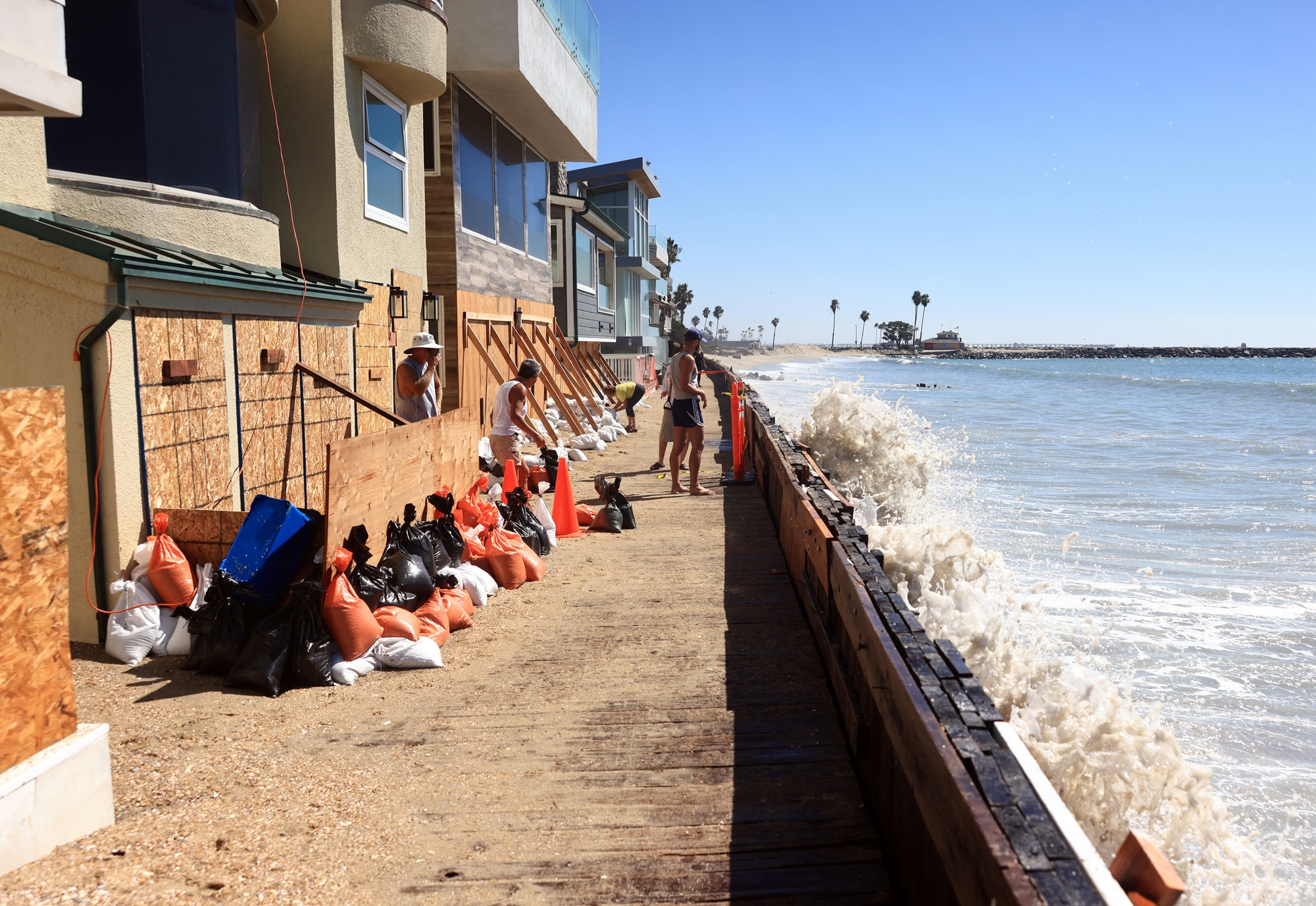 2026年10月9日,熱帶風暴「瑞秋」(Rachel)逼近,加州長灘市(Long Beach)居民使用木板和沙袋來保護自己的房屋免受風暴潮和洪水的侵襲。(David Swanson/AFP via Getty Images)